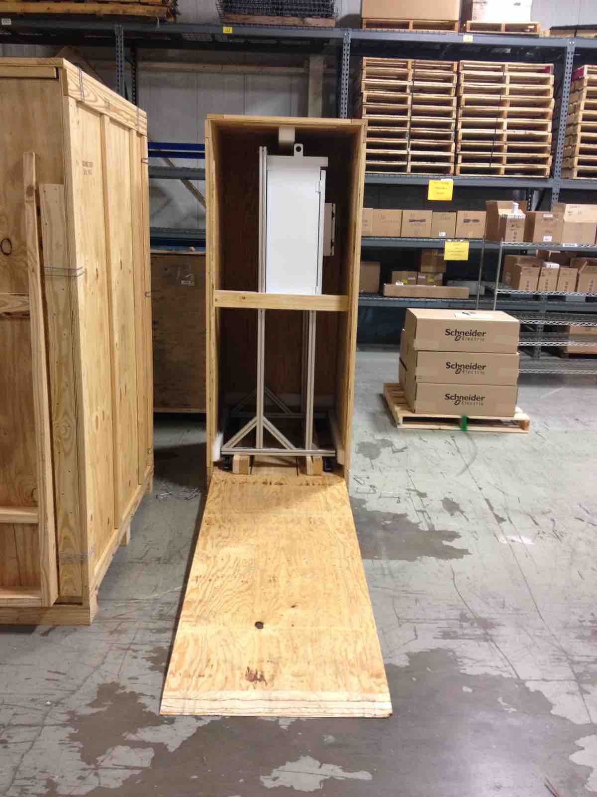 Cabinet crated upright in a tall wooden box with a plywood loading ramp