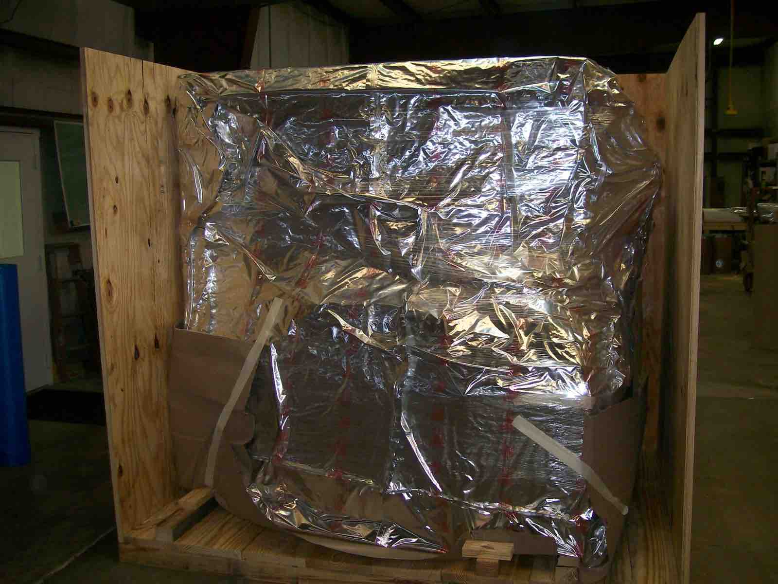 Machine sealed in a foil barrier bag inside an open wooden crate
