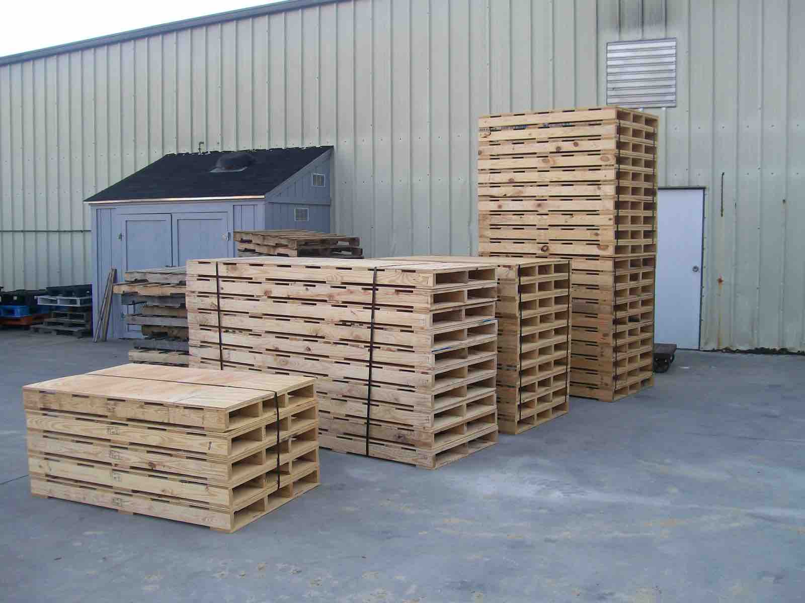 Stacks of new wooden pallets outside a warehouse